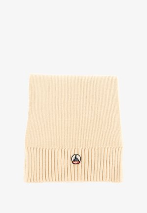 Bufanda de punto beige con textura acanalada, que presenta un parche de logo circular con acentos azules y rojos en la parte inferior. Forma rectangular.