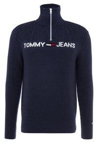 Granatowy sweter z wysokim kołnierzem i ćwierć zippem. Posiada wzór w warkocze na ramionach oraz logo "TOMMY JEANS" w kolorze białym i czerwonym.