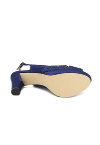 Tacchi slingback in satin blu con punta aperta e parte superiore decorata con piccole pietre brillanti. La parte inferiore è beige con una presa texturizzata.