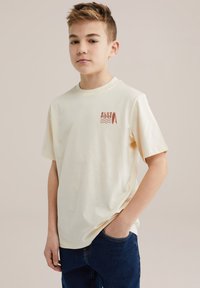 Kremowy t-shirt z krótkim rękawem wykonany z miękkiego materiału, z małym nadrukiem "BLUE RIDGE" oraz wzorem deski surfingowej w kolorze rdzy.