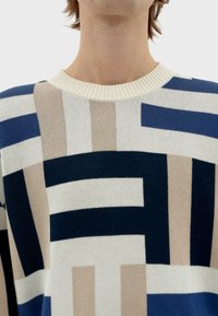 Breisweater met een geometrisch patroon in marineblauw, lichtblauw, beige en roomwit. Ribbelboord voor de ronde hals en een gestructureerde stof.