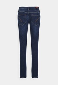 Jeans de mezclilla azul oscuro con corte recto, que cuentan con bolsillos traseros y costuras naranjas en contraste en las costuras. La cinturilla tiene una etiqueta.