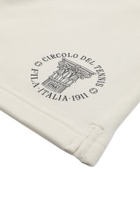 Klassisches Tennis-Logo mit einer verzierten Säule, Tennisbällen und dem Text "Circolo del Tennis FILA Italia 1911" auf hellem Stoff.