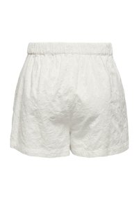 Shorts blancs avec un motif texturé et brodé et une taille élastique. Le tissu semble léger et respirant.