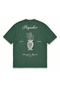 Ciemnozielona koszulka z białą ilustracją wazonu z kwiatami i napisami „Pegador”, „Moments”, „Memories” oraz „Moments to Memories” na plecach.