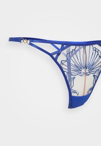 Perizoma blu con ricami floreali, corpo in rete trasparente, cinturini in satin e dettagli in metallo dorato. Forma e design triangolari distintivi.