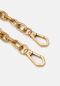 Chaîne en métal doré avec de grands maillons entrelacés et deux fermoirs à clip. La surface présente une finition lisse avec une légère texture.
