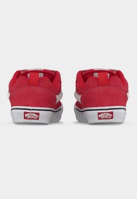 Κόκκινα σουέντ αθλητικά παπούτσια με λευκές λεπτομέρειες, διαθέτουν σχεδιασμό χαμηλού μέσου, στρογγυλεμένο σχήμα και υφή στην επιφάνεια. Περιλαμβάνει λογότυπο της μάρκας στη φτέρνα.