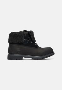 Botas negras de tobillo de cuero con un cuello forrado de felpa, puntera redonda, seis ojales para los cordones y una suela de goma resistente.