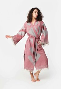 Rúžovo-sivý vzorovaný župan so širokými rukávmi, opaskom v páse a strapcovým lemom. Obsahuje geometrické tvary a mäkkú, textúrovanú tkaninu.