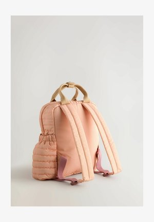 Mochila acolchada rosa con asa beige, correas ajustables, bolsillo lateral y textura suave. Presenta una forma compacta y redondeada con costuras sutiles.