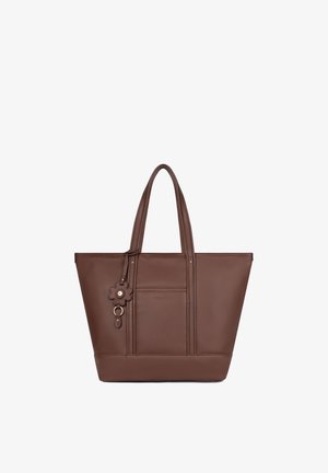 Borsa tote in pelle marrone con doppi manici e un ciondolo a forma di fiore appeso a un manico.