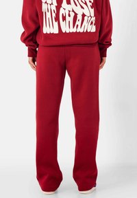 Rode sweatpants gemaakt van zachte fleece, met een relaxte pasvorm en rechte pijpen. Eenvoudig ontwerp, geen zichtbare accenten.