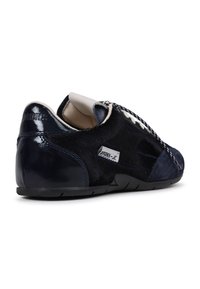 Navy blue sneakers with a mix of leather and textured materials, featuring a zip closure, accent stitching, and a low-profile black sole.