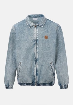Veste en denim bleu clair avec fermeture éclair frontale, deux poches latérales, poignets et ourlet élastiques, et un petit logo rond marron sur la poitrine gauche.