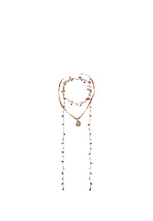 Długi naszyjnik z koralików w kolorach czerwonym, pomarańczowym i białym, z małymi zwisającymi koralikami i centralnym okrągłym wisiorkiem na białym tle.