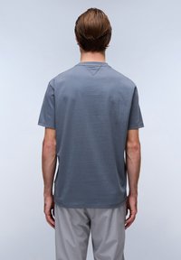 Grå bomulds t-shirt med korte ærmer, rund halsudskæring og lige snit, vist bagfra mod en lys baggrund.
