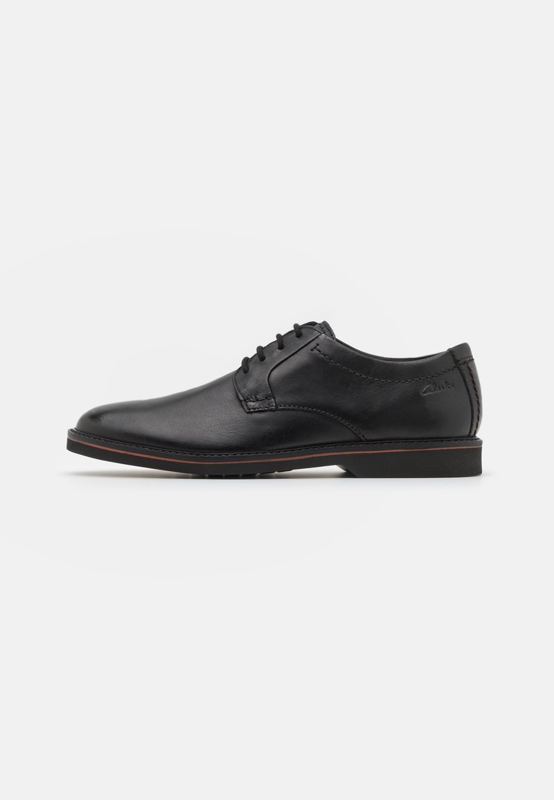 Chaussure de ville noire en cuir pour homme, à lacets, talon bas et semelle cousue, vue de côté sur fond blanc.