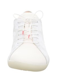 Weiße Sneaker mit einer Veloursleder-Oberfläche, runder Zehenform und kontrastierenden hellen Stoffakzenten. Ausgestattet mit weißen Schnürsenkeln mit roten Spitzen.