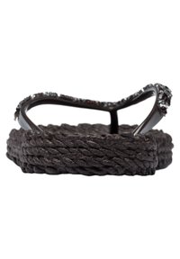 Sandal con suola arrotondata in corda intrecciata marrone e cinturino decorativo con accenti metallici. Il materiale superiore è lucido e liscio.