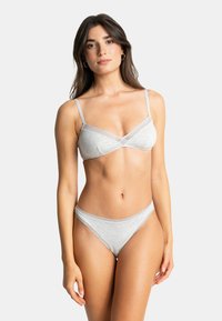 Ensemble de lingerie gris clair en tissu doux ; le soutien-gorge présente des bretelles fines et des accents en dentelle, le string assorti est orné d'une délicate bordure en dentelle.