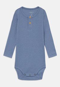 Långärmad babynest i mjukt blått ribbat tyg. Har en henley-krage med två träknappar och tryckknappar i botten.