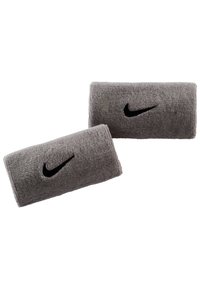 Muñequeras de toalla gris con un logo negro de Nike, superficie texturizada y forma rectangular, diseñadas para uso atlético.