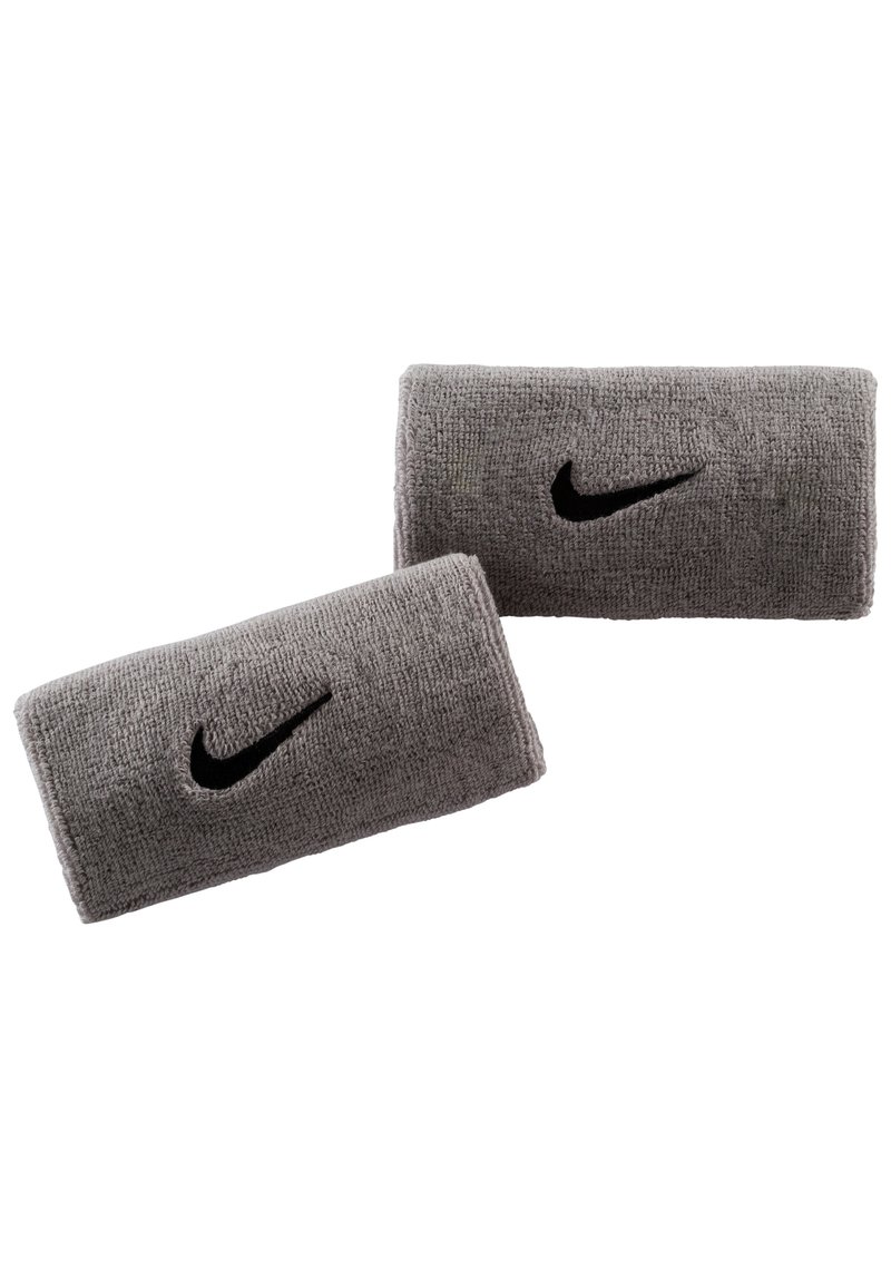 Muñequeras de toalla gris con un logo negro de Nike, superficie texturizada y forma rectangular, diseñadas para uso atlético.