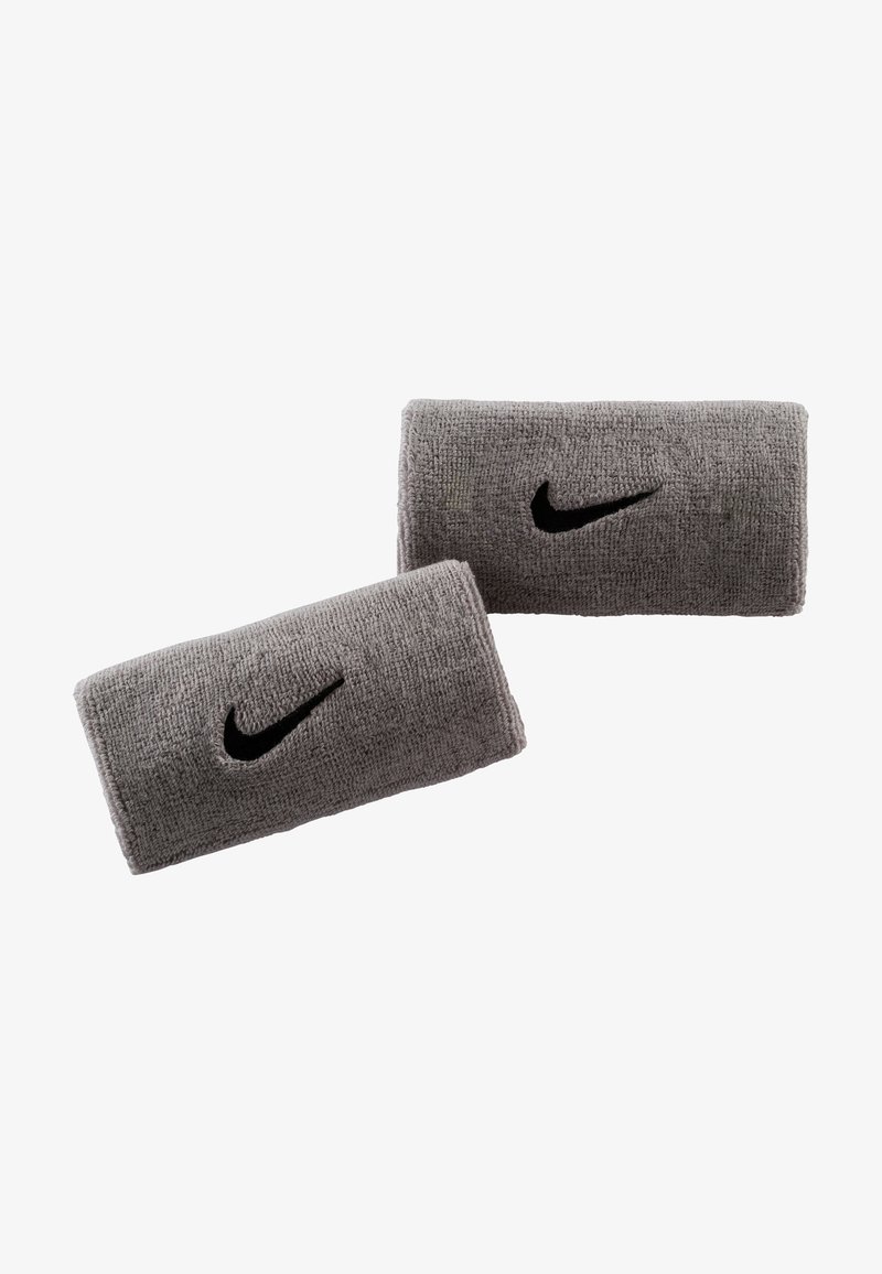 Pelēki frotē auduma plaukstas sargi ar melnu Nike logo, teksturētu virsmu un taisnstūrveida formu, kas paredzēti sportiskai lietošanai.