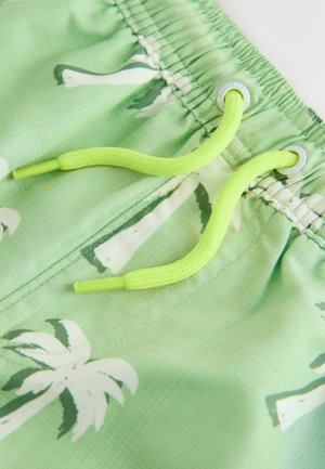 Pantalones cortos de baño verde claro con patrones de palmeras blancas, con un tejido texturizado y un cordón de neón verde para ajuste.