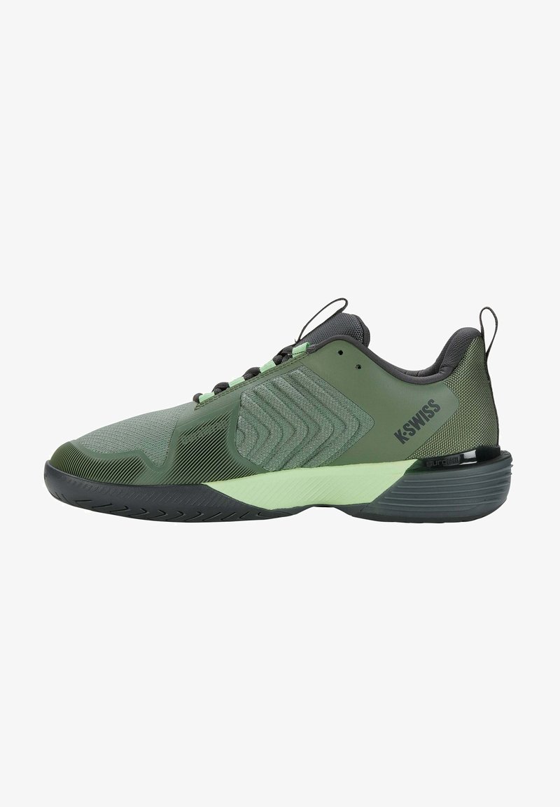 Chaussure de sport K-Swiss verte et noire avec tige texturée, panneau latéral à motif et semelle rembourrée sur fond blanc.