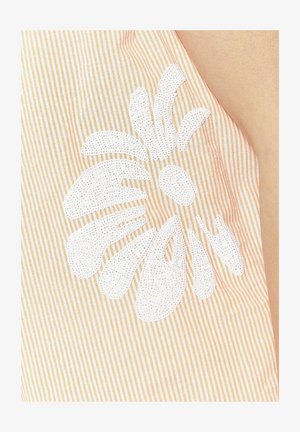 Triibuline kangas helesesami ja valgega, millel on tekstuuriga valgest lillede kujundus, millele on lisatud kaunistusi, rõhutades detaile ja kontrasti.