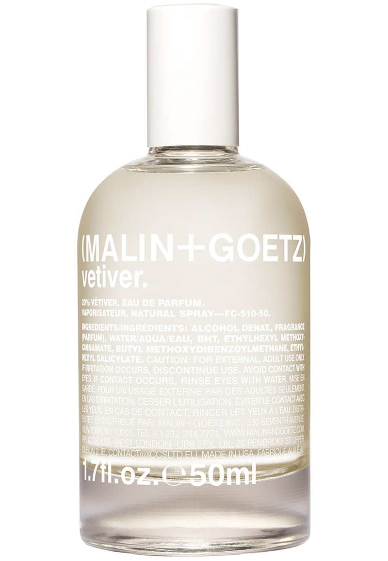 Durchsichtige Sprühflasche aus Glas mit runder Basis und leicht konisch zulaufendem Hals. Weiße Kappe. In Weiß gedruckter Text, der das Parfüm und die Inhaltsstoffe beschreibt.