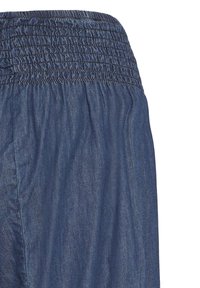 Jupe en denim bleu avec une large ceinture élastique et un tissu froncé sous la taille pour une coupe décontractée.