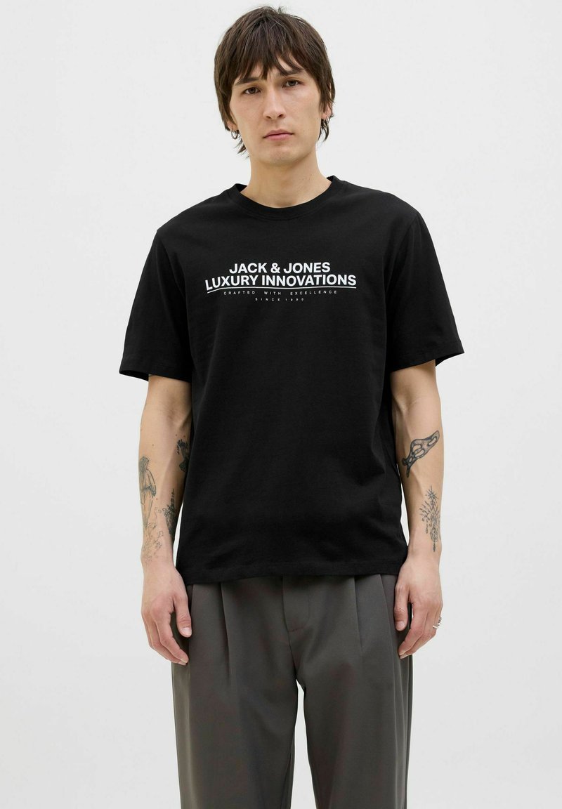Svart bomull t-shirt med vit textlogotyp "JACK & JONES LUXURY INNOVATIONS". Kort ärm, rund halsringning, avslappnad passform. Inga synliga mönster.