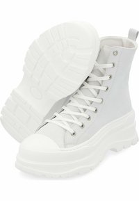 Zapatillas altas blancas con parte superior de ante texturizado, puntera de goma blanca, suela gruesa y ojales de metal para los cordones.