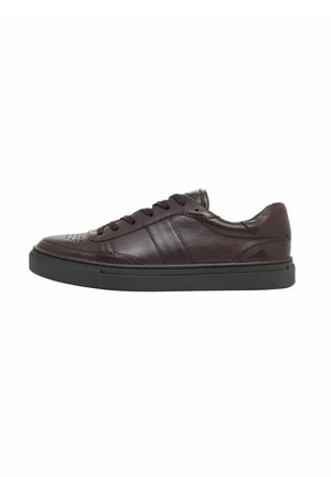 Niskie sneakersy z ciemnobrązowej skóry z czarną gumową podeszwą i czarnymi sznurowadłami, widok z boku na białym tle.