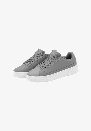Zapatillas sintéticas grises con cordones planos, punta redondeada y un acabado suave. Suela de goma blanca y un sutil detalle de costura lateral.