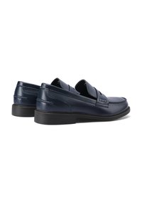 Mocassini in pelle blu navy con dettagli di cucitura decorativa, design slip-on e suola in gomma. Presentano una finitura liscia e lucida.