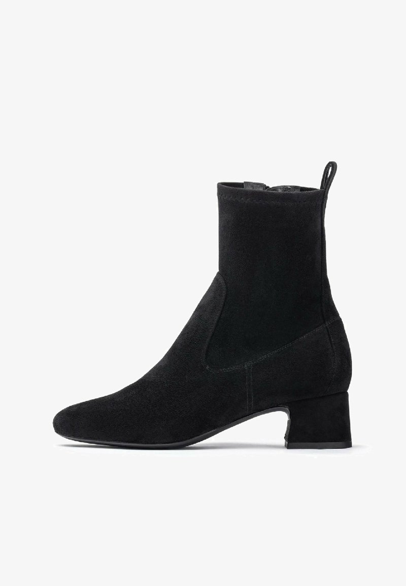 Stivale alla caviglia in suede nero con tacco basso a blocco e zip laterale, dotato di una linguetta sul retro.