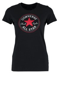 Camiseta de algodón negra con un logotipo rojo redondo que presenta una estrella y el texto "Converse Chuck Taylor All Star" en blanco. Diseño estándar de cuello redondo.
