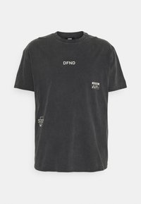 T-shirt en coton noir avec logo "DFND" imprimé sur le devant et petites étiquettes sur les côtés inférieurs. Encolure ronde et design décontracté.