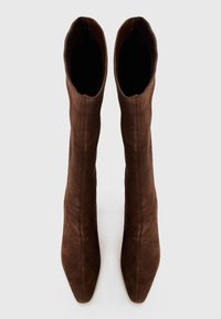 Brown suede ankle boots with a sleek, fitted design, pointed toe, and smooth texture, featuring a tall shaft extending to mid-calf.