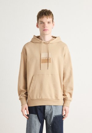 Beige hooded sweatshirt met een front pocket en een vierkant logo ontwerp. Gemaakt van zacht materiaal, met trekkoorden voor aanpassing bij de capuchon.