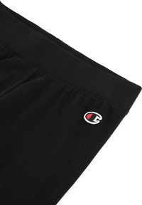 Pantaloni neri in cotone con una vita elastica e dettagli cuciti. Presenta un piccolo logo ricamato in rosso e bianco.