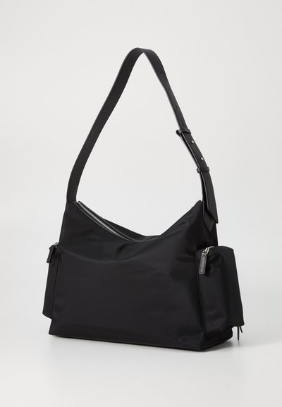 Black shoulder bag made of smooth fabric with a zippered top, adjustable strap, and a side pocket with a small zipper detail.