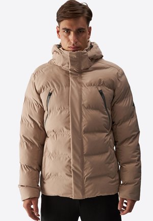 Chaqueta acolchada beige con cuello alto y capucha. Presenta dos bolsillos con cremallera y un diseño liso e insulated. Superficie texturizada visible.