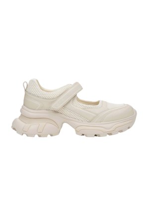 Beżowe sneakersy z siateczkową cholewką, regulowanym paskiem na rzep oraz masywną gumową podeszwą z teksturowanym bieżnikiem zapewniającym przyczepność.