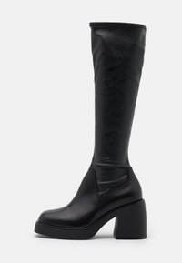 Polvihavaiset mustat tekonahkabootsit, joissa on paksu lohkopohja, sileä pinta ja sivusauma yksityiskohtia. Sopivat erilaisille asuille.