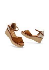 Sandalias de cuña de ante marrón con punta descubierta, tira en el tobillo y detalle trasero trenzado. Suela de plataforma texturizada con acentos de costura.